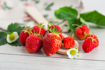 Juicy strawberries close-up on a light wooden table