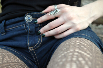 part of the girl's body is blurred. woman's hand on the hip, trouser line, belt, blue denim shorts....