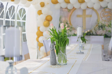 Garden tent for a communion party with a table and white decorations.