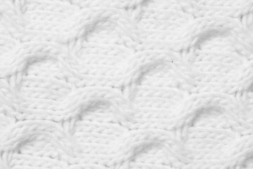 Texture of white knitted fabric with pattern as background, top view