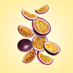 Delicious ripe passion fruits falling on pale yellow gradient background