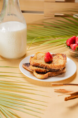 Traditional Latin American sweet bread toast with strawberry and milk, tropical setup

