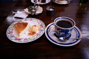 花柄のプレートにのったチーズケーキとブルーのカップのコーヒーセット

