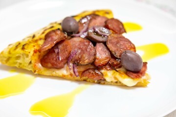 Delicious pizza slice with sausage and olives. Traditional Brazilian calabresa pizza 