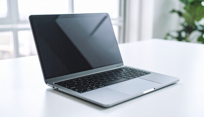 Fototapeta premium Sleek Silver Laptop on White Desk, Modern Workspace