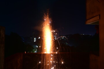 A dazzling firework fountain erupts with bright sparks in the dark.