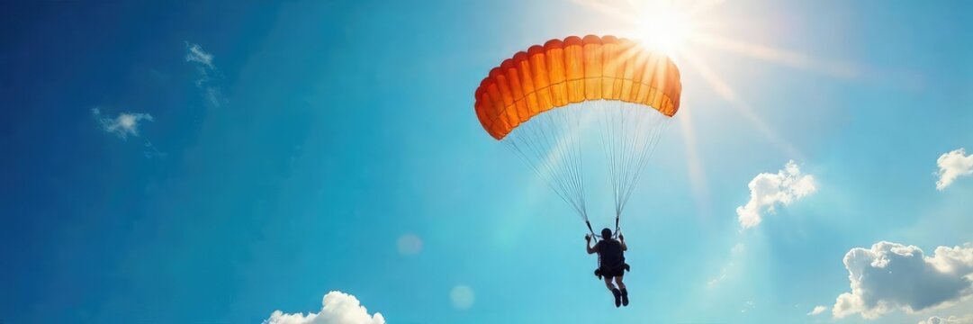 Breathtaking aerial view of a skydiver gracefully falling against a vibrant blue sky, sunlight illuminating the parachute A stunning display of freedom and adventure , sunlight, sky