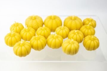 A group of beeswax Halloween yellow pumpkin candles isolated on white background