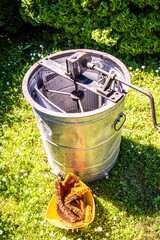 Barrel of honey extractor and with honeycomb next to it