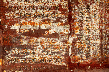 Rusty exterior door marked by old advertisements that left abstract traces.