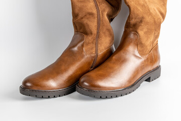 Stylish brown leather and suede knee-high boots with side zipper and buckle detail.