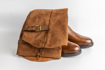 Brown leather and suede knee-high boots with buckle detail and side zipper folded over.