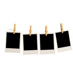 Four Blank Instant Photos Hanging with Clothespins on a String Against a Black Background for Mockup Purposes