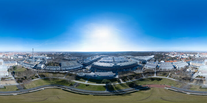 Berlin Messe 360 Drone Shot of Historic Halls and a Plane Soaring Over the Bright Sun, Framed by a Vibrant Sky and Bold City Skyline