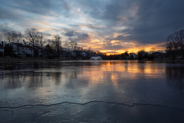 Stunning sunset reflections, on a partially frozen suburban pond