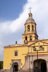 Obraz premium Cúpula del Santuario y Convento de la Santa Cruz de los Milagros, Queretaro, México, Religión Católica, cruz cristiana en la punta de campanario con arcos, amarillo colonial