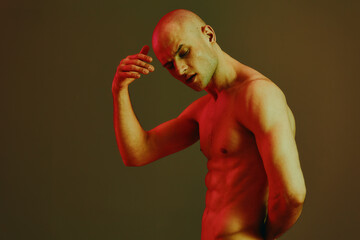 Thoughtful man in a striking pose, featuring a blend of warm red tones and a minimalist backdrop....