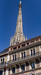 Vienna, Austria - 05 19 2024: The main spire of St Stephens Cathedral rises behind a beautiful building facade in the center of Vienna.