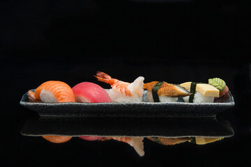 salmon, tuna, ebi, prawn, eel, tamago, nigiri sushi on a plate 