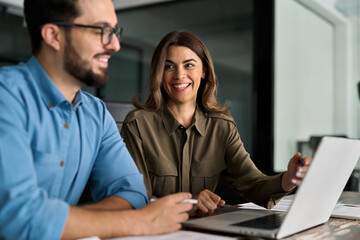 Happy busy female manager explaining corporate software work talking to young male employee...