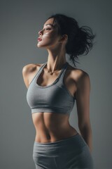 Fototapeta premium A woman is wearing a grey tank top and grey pants