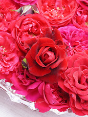 Red roses on water in glass bowl.
