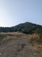 Dusty mountain trail leading up to a hilltop