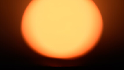 Glowing orb of the sun during sunset close-up. Out of focus Sun