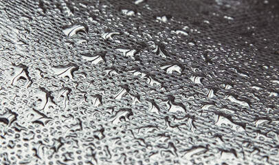 water droplets on textured surface, creating natural patterns. Water droplets on fabric surface, reflecting light in different directions. Abstract macro of water droplets on a fabric texture,