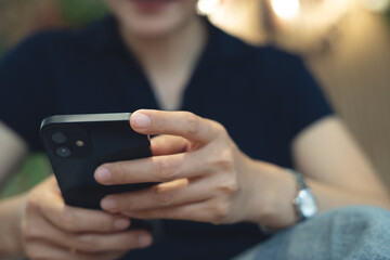 Close up of Young asian woman using smartphone for online shopping and internet banking via mobile app. Smiling woman typing on mobile phone, surfing the net and social media network