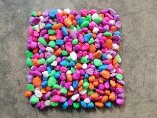 Colorful stones in square shape on abstract background. 
A square arrangement of colorful pebbles...