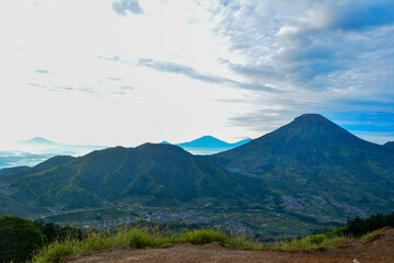 Fototapeta premium Mountainous landscape captured from Sikunir Hill in the Dieng Plateau, Central Java, Indonesia, renowned for its breathtaking sunrise views, particularly of Mount Sindoro. Represent natural beauty