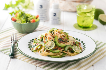 【ゴーヤと梅肉のパスタ】さっと茹でたゴーヤと梅肉・大葉・松の実を和えた夏のパスタ。仕上げに酢橘のスライスを散らして爽やか風味を楽しみます。