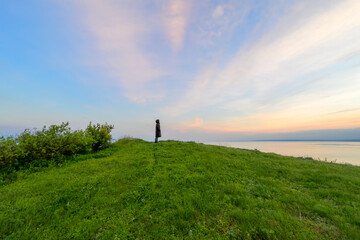 Silent Observer: A lone figure silhouetted against a vast sunset sky over the serene Black Sea coast. © VasilAndreev Photo