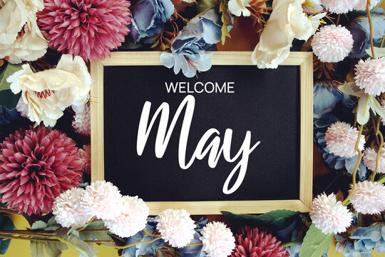 Welcome May text with flowers decoration on yellow background