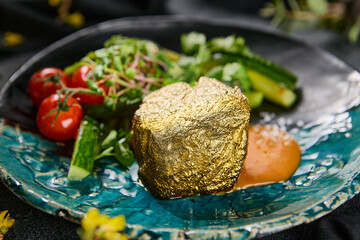 Fillet mignon steak in edible gold leaf with smashed cucumbers and tomatoes, vibrant lighting,...