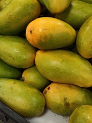 Rows of fresh, sweet mango fruits in a supermarket,Hileras de frutas de mangos frescos y dulces, ...