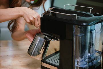 Barista grinding coffee beans and pouring espresso from machine in café, showing close-up of...