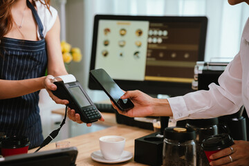 A smiling barista serves a customer at a modern café counter, showcasing friendly service, small business spirit, and coffee culture.