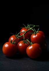 Fresh ripe red tomatoes on the vine still life food photography dark background