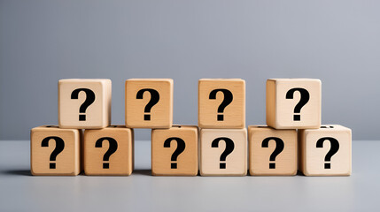 Wooden blocks with question marks stacked on gray background