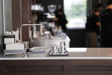 A small glass of water is placed upside down on the table. Clean drinking glasses are placed on the counter for use.