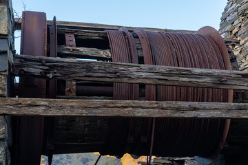 Close-up view of a rusting industrial winch drum with thick steel cables