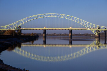 The Silver Jubilee Bridge, also known as the Runcorn Bridge, captured on a calm, clear day with the entire structure reflected in the still water below