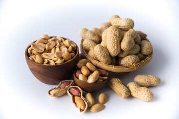 Peanuts in basket a collection of whole peanuts in their shells and a few without shells,healthy snacking concept with peanuts rich in protein, isolated on white background.