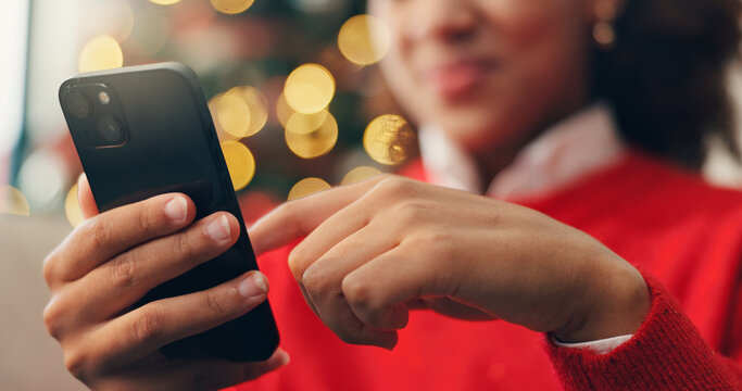 Christmas, hands and phone with person in living room of home for online shopping or retail. App, browsing and social media with customer at bokeh in apartment to purchase gift or present on mobile - Powered by Adobe