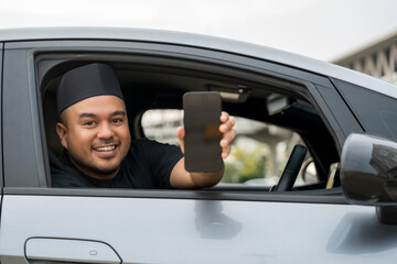 Asian muslim business man getting new car holding smartphone. Happy and excited. Smiling man...