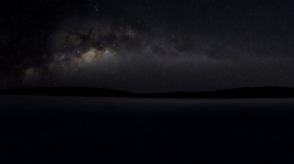 Milky Way over a dark landscape