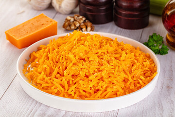 Yellow shredded cheddar cheese in the bowl