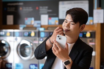 Gay man makeup artist applying lipstick in laundry shop